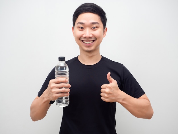 Homme asiatique tenant une bouteille d'eau et pouce vers le haut sourire heureux, homme gai avec une bouteille d'eau