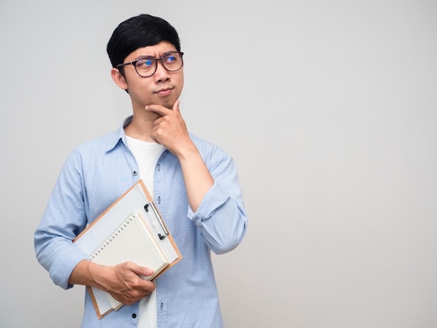 Un homme asiatique tient un geste de journal en pensant à l'apprentissage isolé