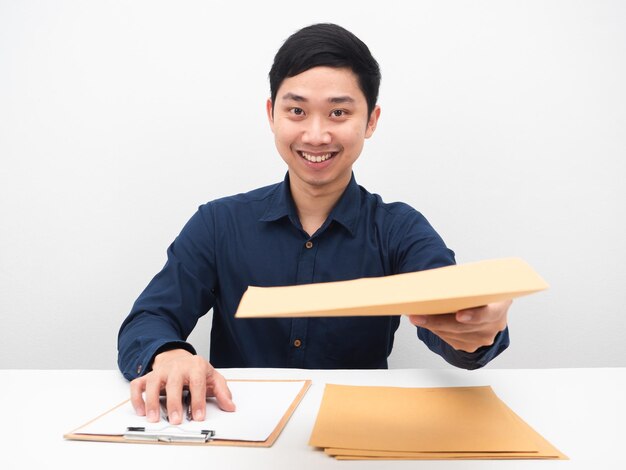 Un homme asiatique vous donne une enveloppe de document pour une émotion heureuse et un visage souriant