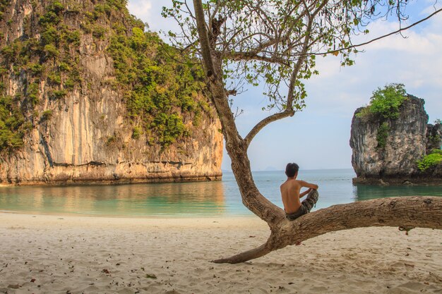 Photo un homme assis sur un arbre