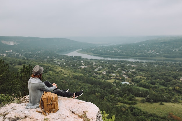 Homme assis au sommet de la montagne avec belle vue.