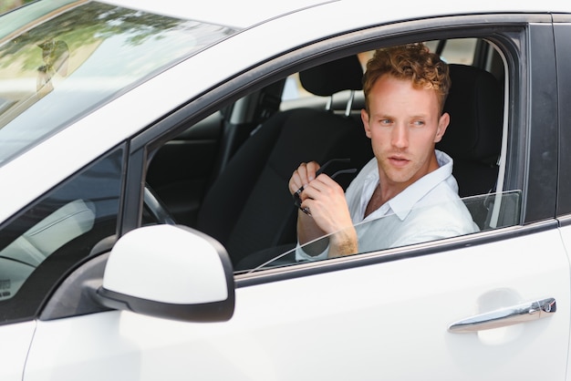 Homme assis au volant d'une voiture électrique