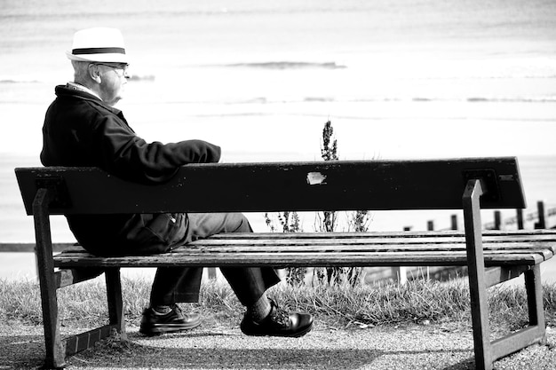 Photo un homme assis sur un banc dans un parc.