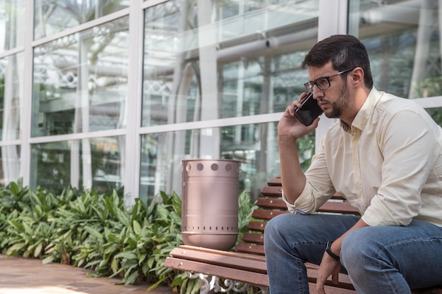 Homme Assis Sur Un Banc Parlant Au Téléphone