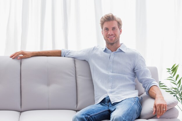 Homme assis sur un canapé dans le salon