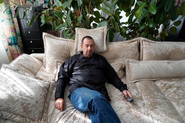 un homme assis sur le canapé et regardant la télévision