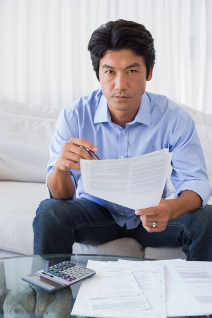 Homme assis sur un canapé à travailler sur ses finances