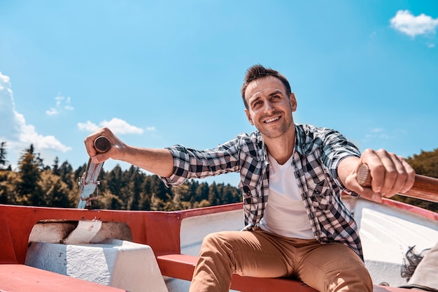 Homme assis en canoë et naviguant sur le lac