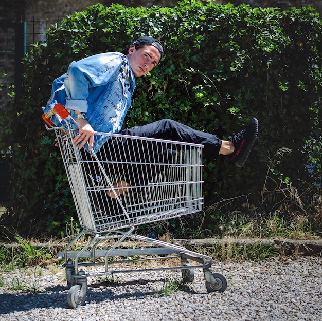 Un homme assis sur un chariot d'achat