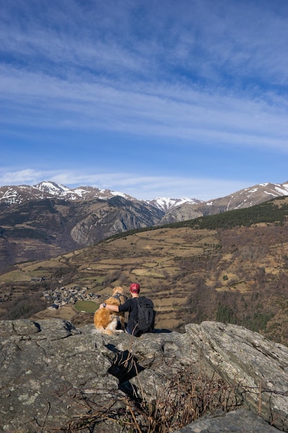 Homme assis à côté d'un chien