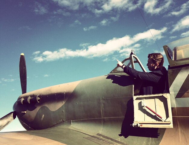 Photo un homme assis dans un avion contre le ciel