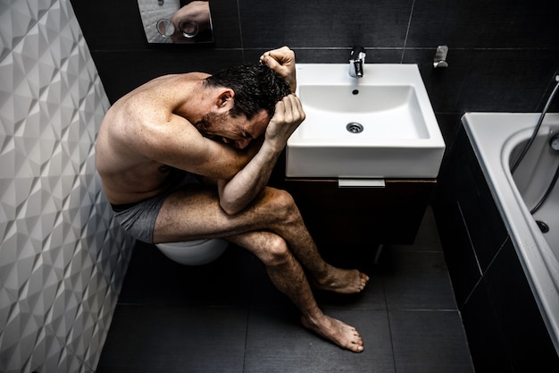 homme assis dans la salle de bain