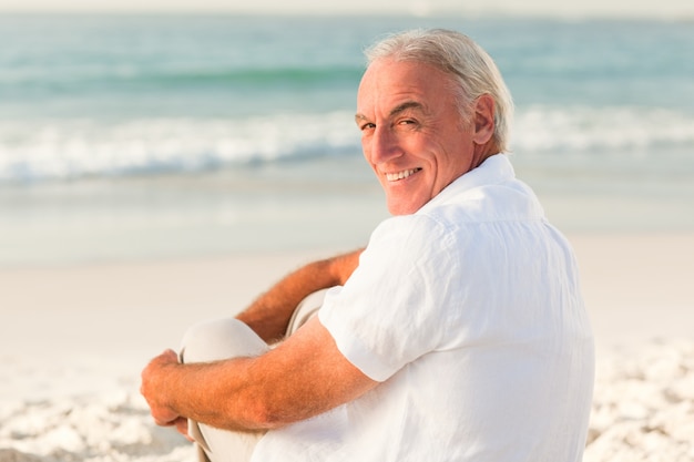 Homme assis sur la plage