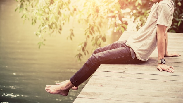 Homme assis sur le pont de bois