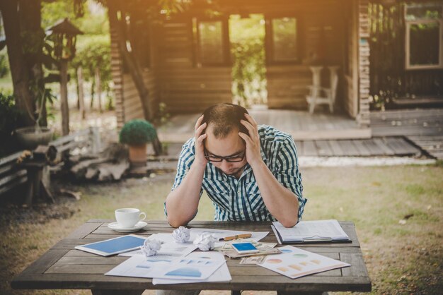 Photo un homme assis à la table à l'extérieur