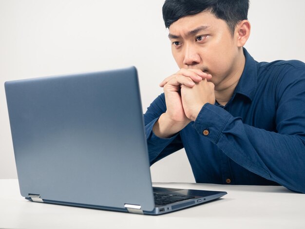 Homme assis à table regardant un ordinateur portable émotion grave Employé masculin