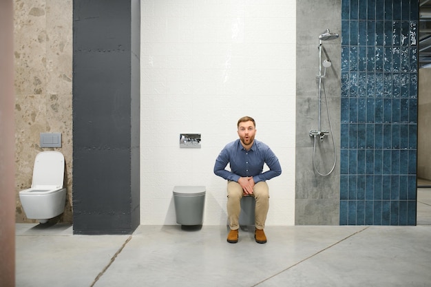 Photo un homme assis sur les toilettes dans un magasin de plombier