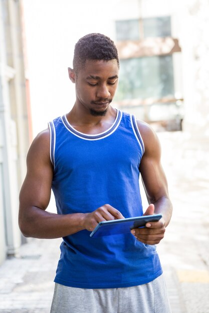 Homme athlétique à l&#39;aide de la tablette tactile