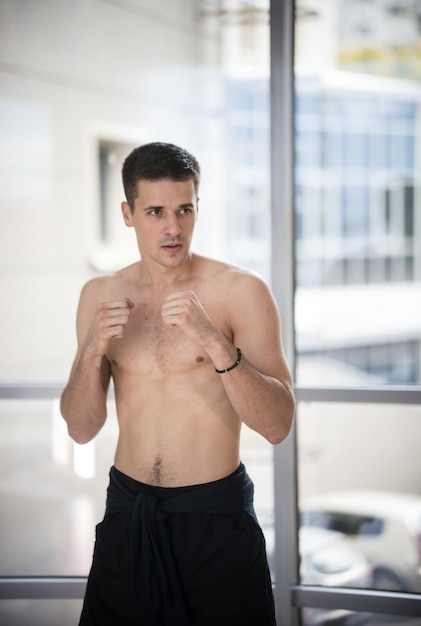 Un homme athlétique debout dans la pose de combat dans le studio