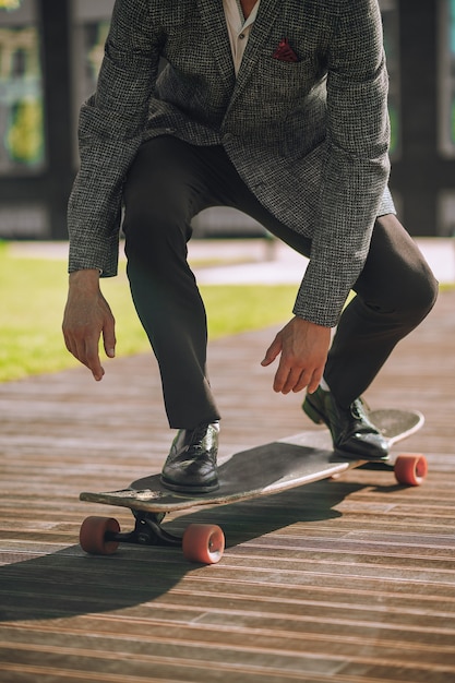 Photo homme athlétique élégant faisant de la planche à roulettes le matin