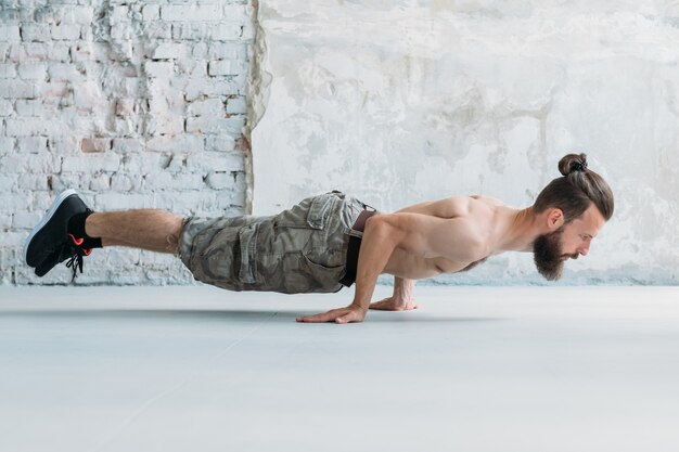 Homme athlétique d'endurance de force d'exercice statique