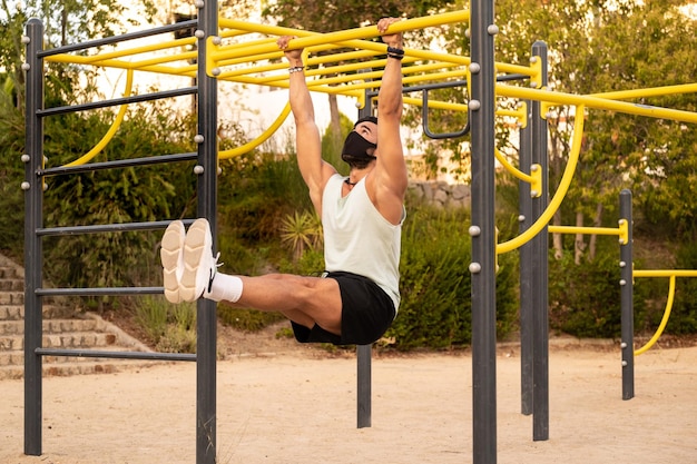 Homme athlétique faisant des chin-ups dans une aire de jeux