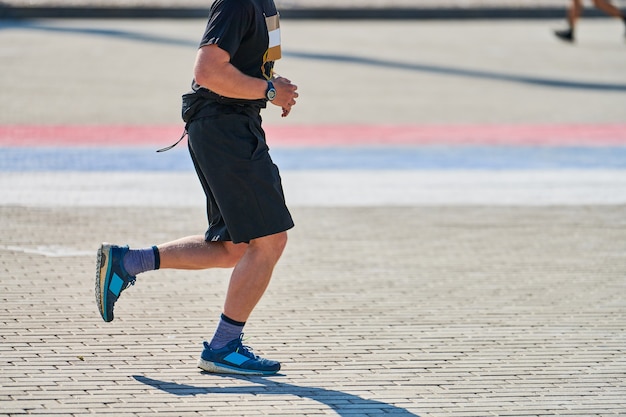 Homme athlétique jogging en tenue de sport dans la ville