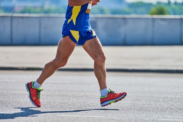 Homme athlétique jogging en tenue de sport sur route de la ville