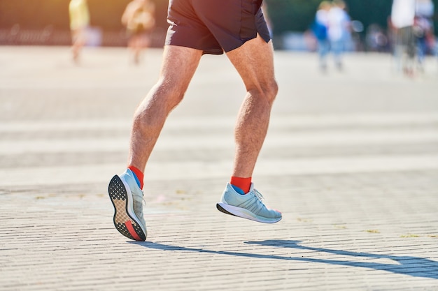 Homme athlétique jogging en tenue de sport sur route de la ville