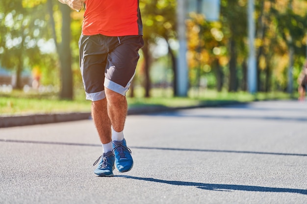 Homme athlétique jogging en tenue de sport sur route de la ville