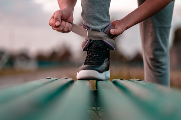 Homme athlétique met des poids sportifs pour marcher pendant l'entraînement en plein air. Mode de vie sain et sportif.