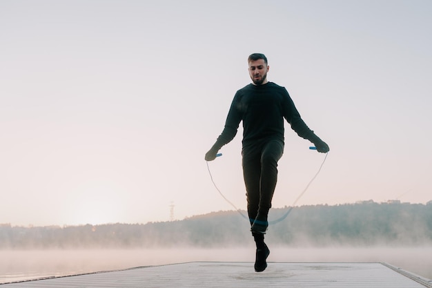 Homme athlétique sautant la corde à l'extérieur