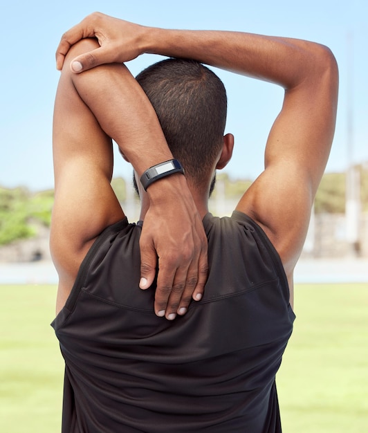 Homme athlétique se préparant à la forme physique et à l'exercice en s'étirant et en s'échauffant à l'extérieur sur un terrain de sport Athlète masculin passant par sa routine d'échauffement avant l'exercice ou un entraînement cardio ou d'endurance