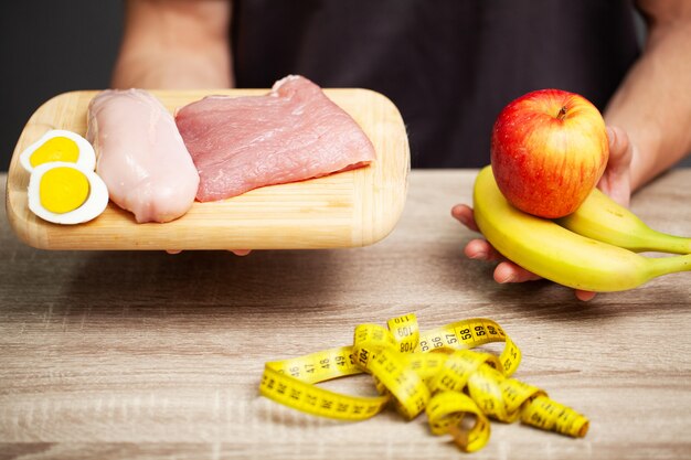 Homme athlétique tenant une planche avec de la viande pour une bonne nutrition de l'athlète