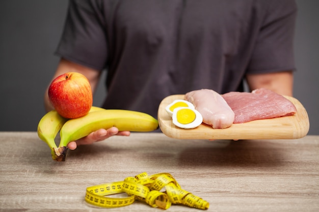 Homme athlétique tenant une planche avec de la viande pour une bonne nutrition de l'athlète