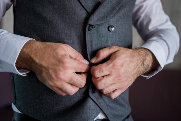 L'homme attache un bouton sur une veste