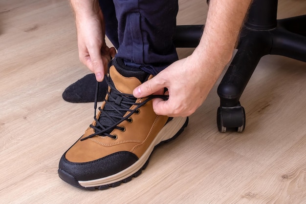 Un homme attache ses lacets de près