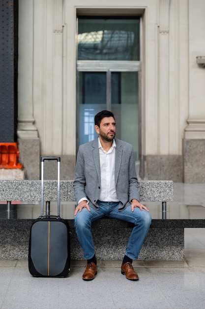 Homme attendant avec valise