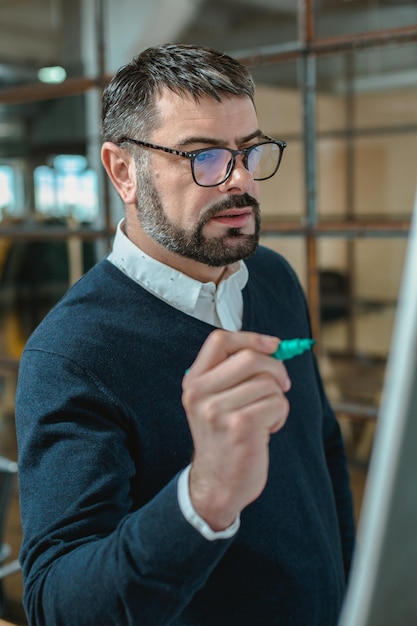 Homme attentif va écrire sur tableau blanc