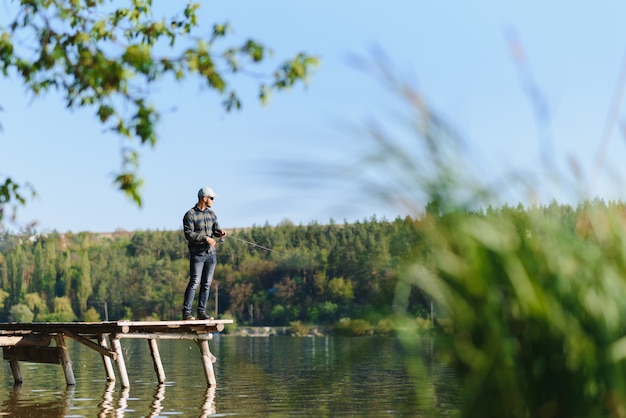 Un homme attrape un poisson sur une pêche en rotation en été