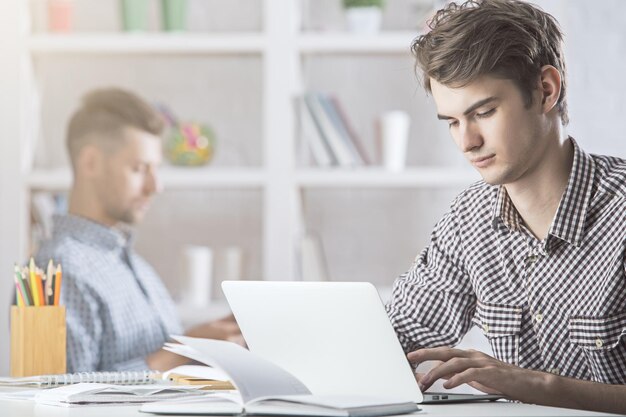 Homme au bureau à l'aide d'un ordinateur portable