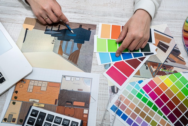 Homme au bureau sélectionne une palette de couleurs pour les dessins de la maison sur le projet