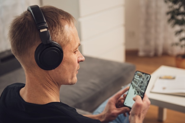 L'homme au casque et avec un smartphone. Vue arrière.