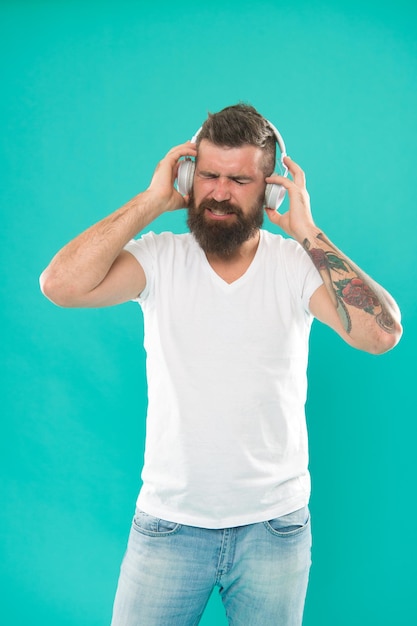 Homme au casque Les sources de musique en ligne gratuites fonctionnent toutes un peu différemment et ont de nombreuses fonctionnalités différentes Graphique musical Hipster mature avec barbe écoutant de la musique Mélomane élégant et beau