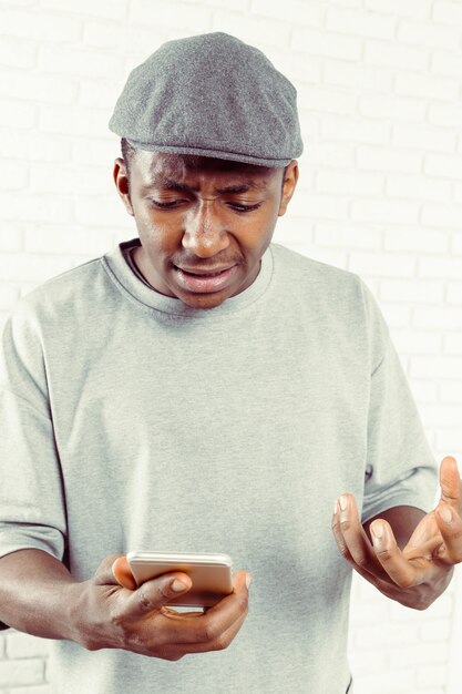 Homme au chapeau gris à la recherche de son smartphone