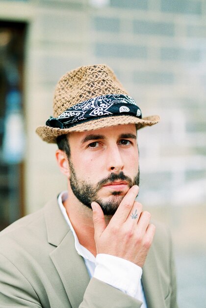 L'homme au chapeau touche son menton avec ses doigts