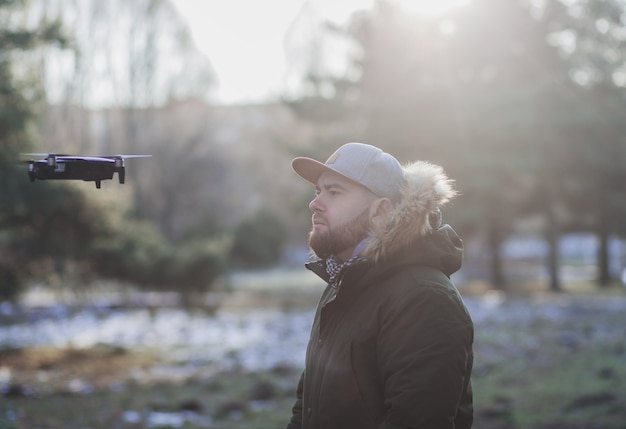 Homme au chapeau volant avec un drone sans fil à l'extérieur