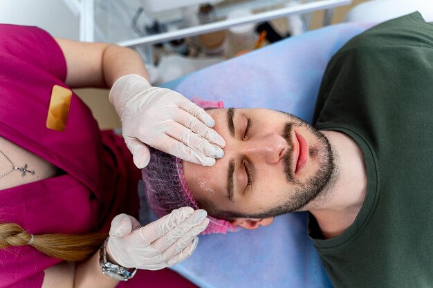 Homme au cosmétologue Détente temps d'attente visage gros plan vue de dessus Concept de l'industrie de la beauté Guy appréciant en cosmétologie