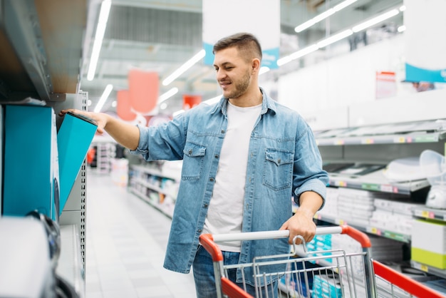 Homme au département des appareils ménagers, marché