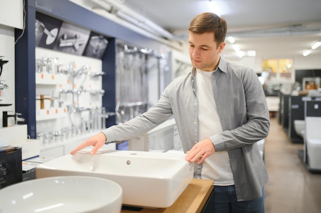 Un homme au marché de la construction à la recherche d'un évier dans leur salle de bain